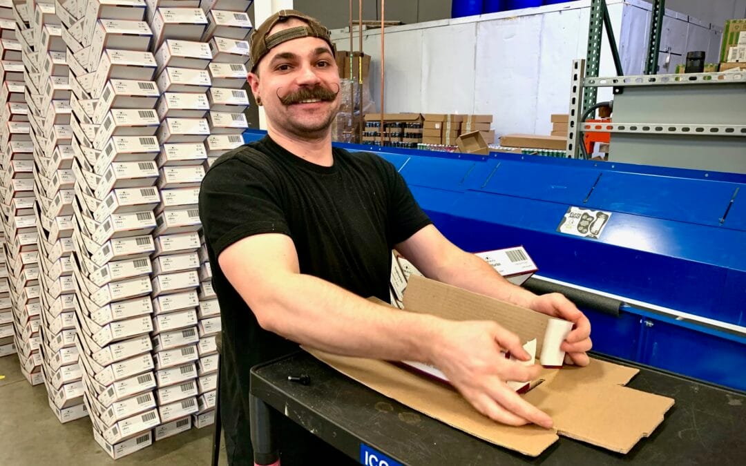 Good Trade Depot staff member packing canned beverages in the Kalamazoo production facility Good Trade Depot staff member packing canned beverages in the Kalamazoo production facility