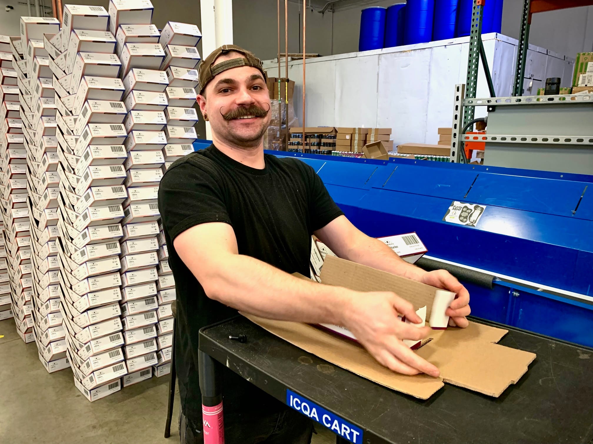 Good Trade Depot staff member packing canned beverages in the Kalamazoo production facility